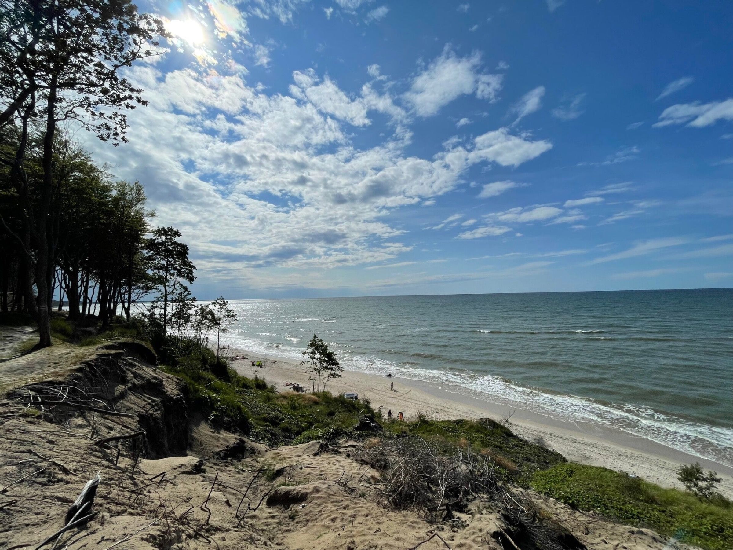 Widok ze skarpy na szeroką plażę i morze w słońcu